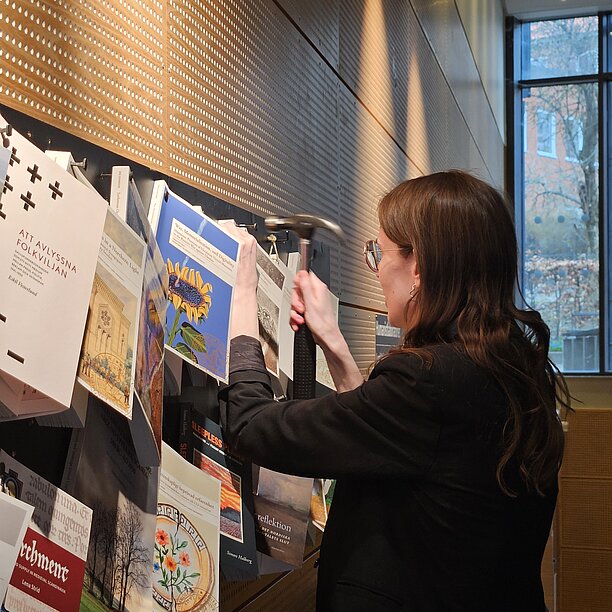 Sarah spikar sin avhandling på spikbrädan. Foto.