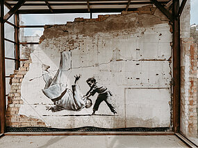 Banksy grafitti med liten judokille som kastar ner en större judokille.